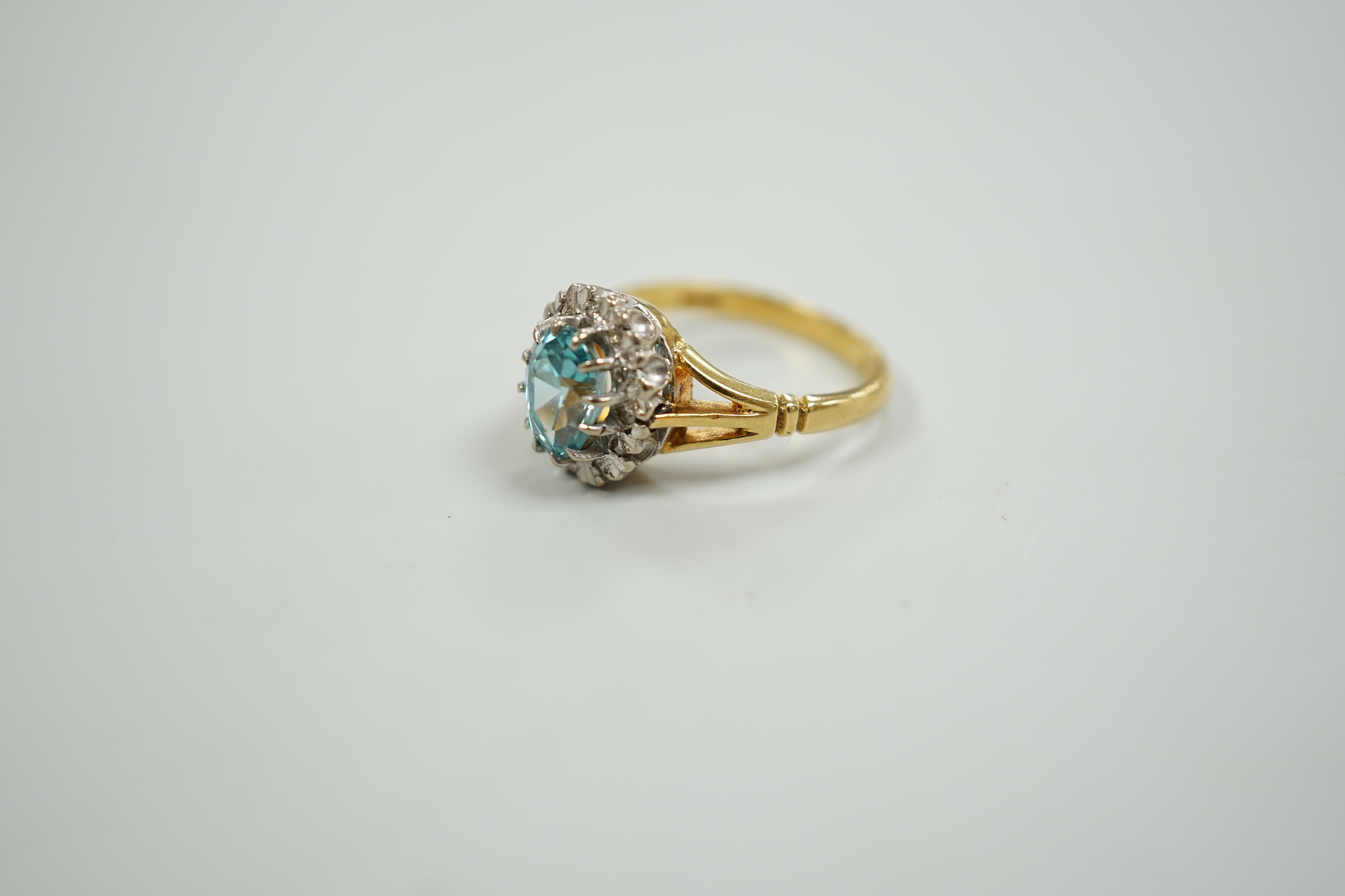An 18ct, blue zircon and illusion set diamond oval cluster ring, size M, gross weight 5 grams.